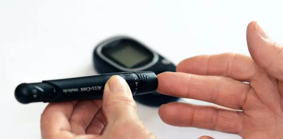 Persona midiendo su glucosa con un medidor de glucosa. Mejora tu manejo de la diabetes con GlucosaPro y monitorea tu salud de cerca.